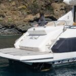 Un yate Sunseeker amarrado en aguas tranquilas, con el nombre "Pacha" visible en la parte trasera.